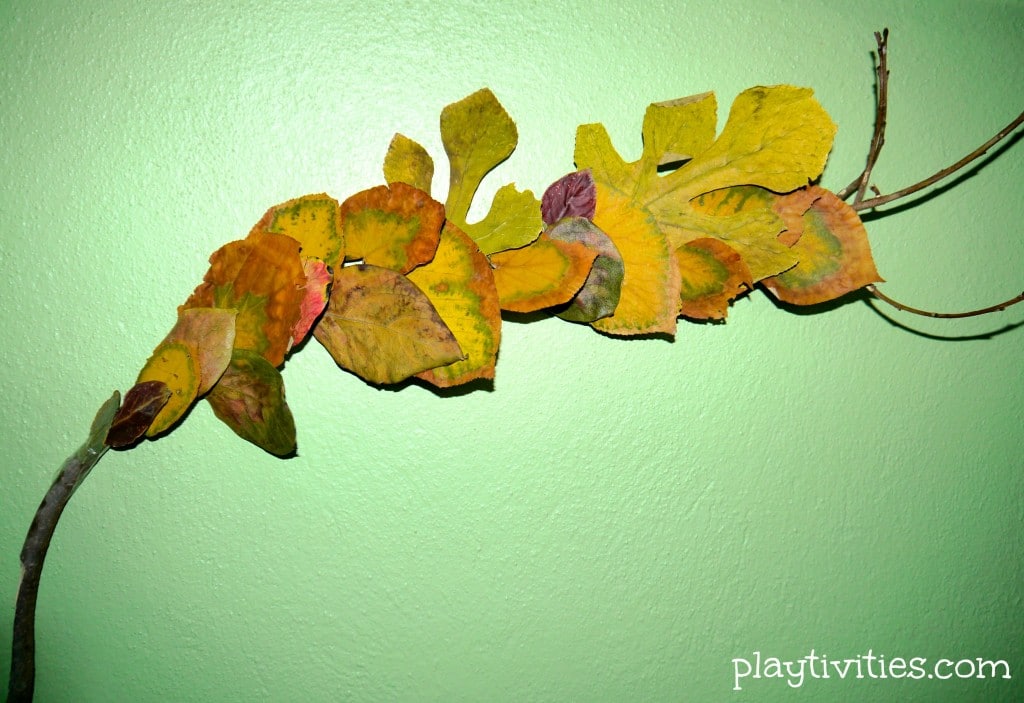 Dried leaves craft on a green wall.