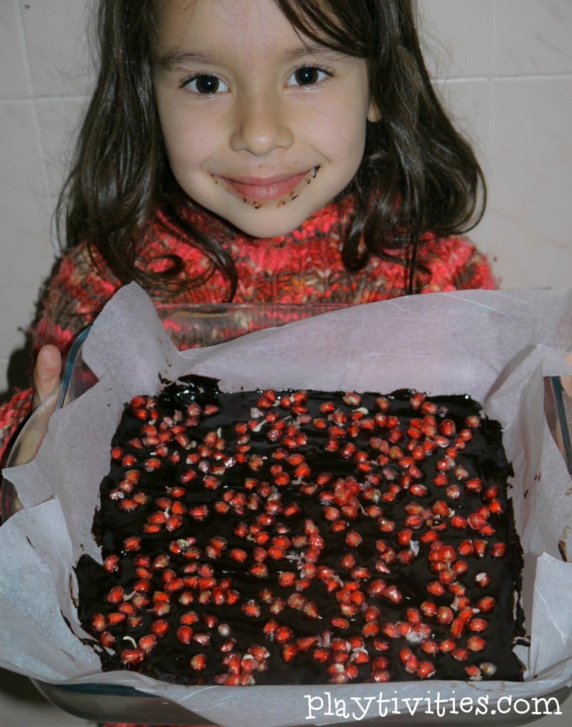 Young girl holding a pan with a cake.