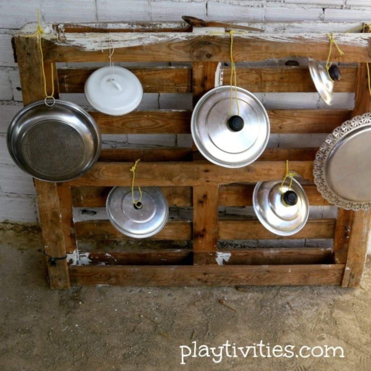 Homemade drums from pots and lids on a wooden palet.