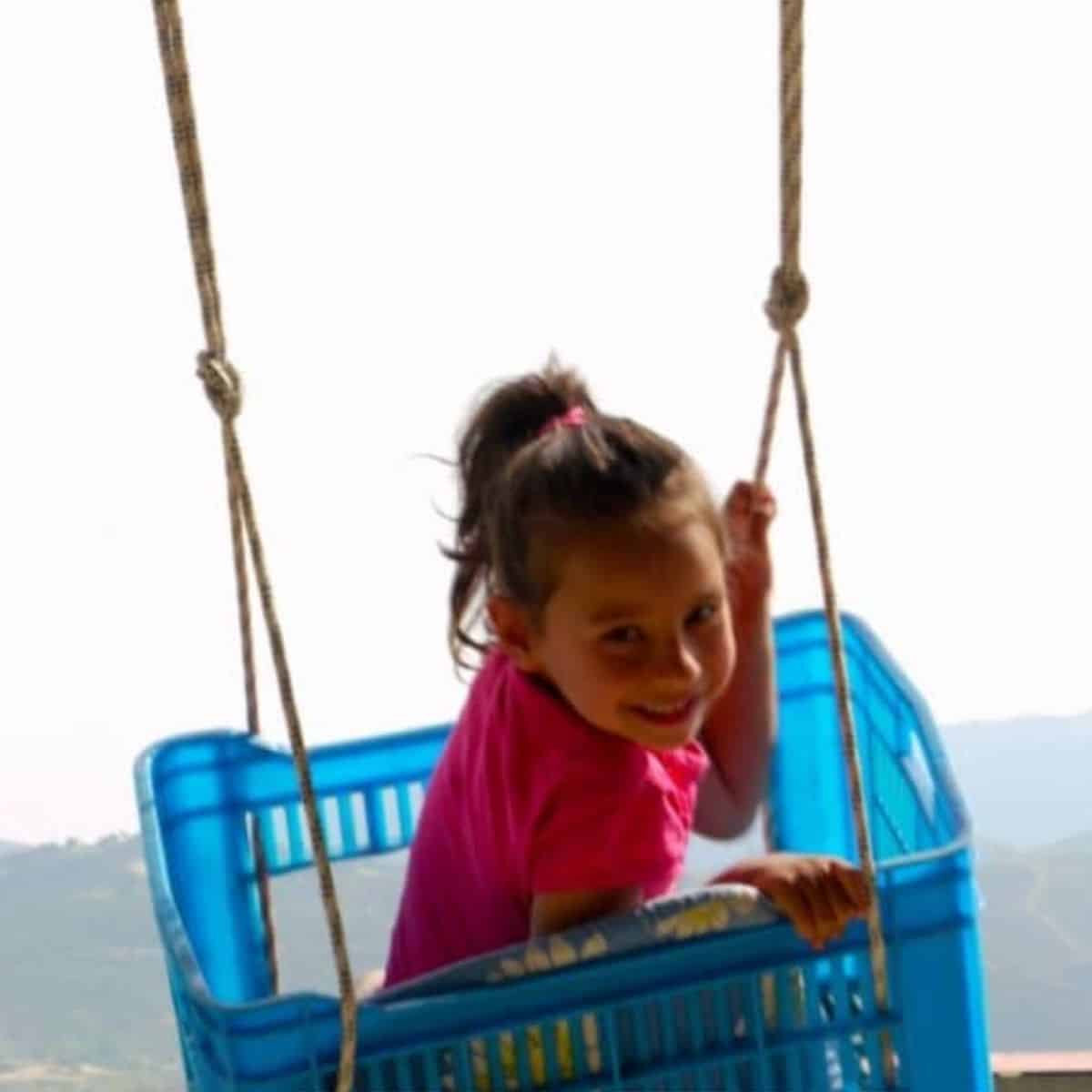 Happy young girl in a plastic swing.