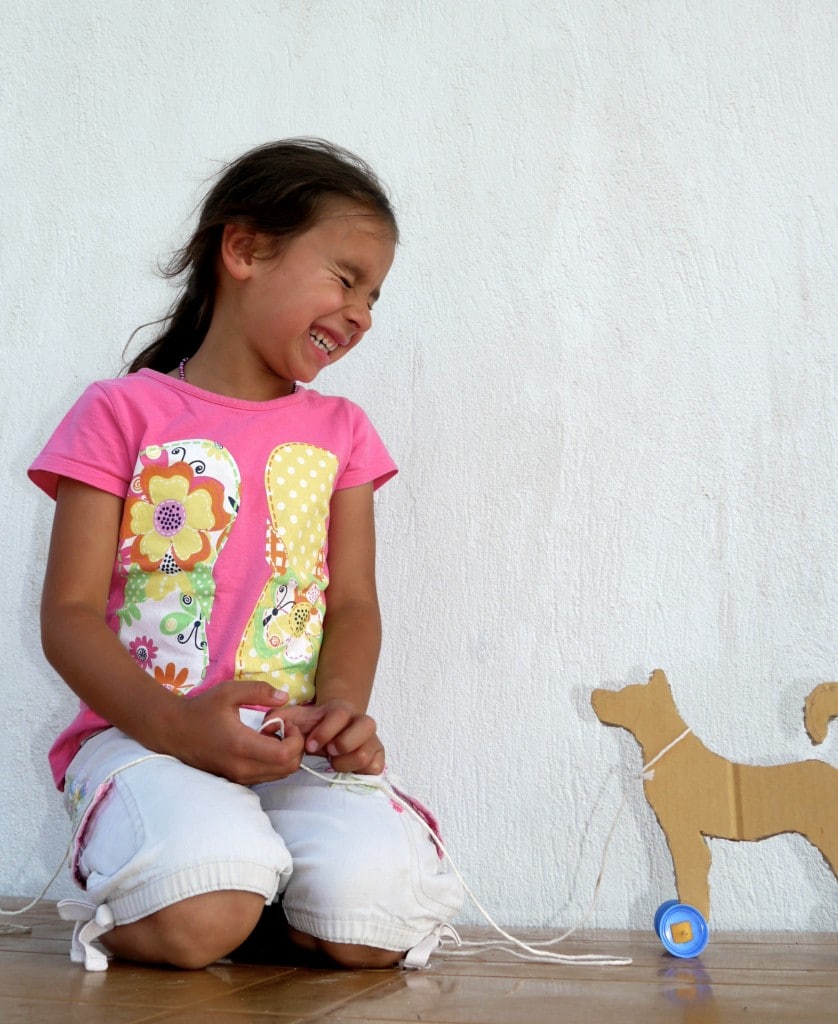 Young girl palying with a cardboard puppy