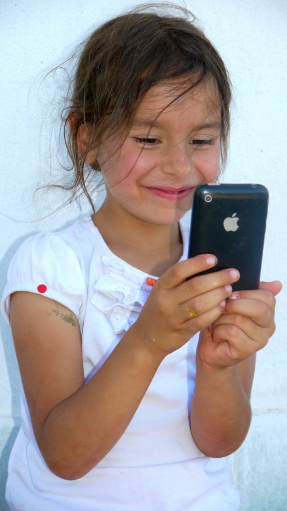 Young girl holding an Iphone.