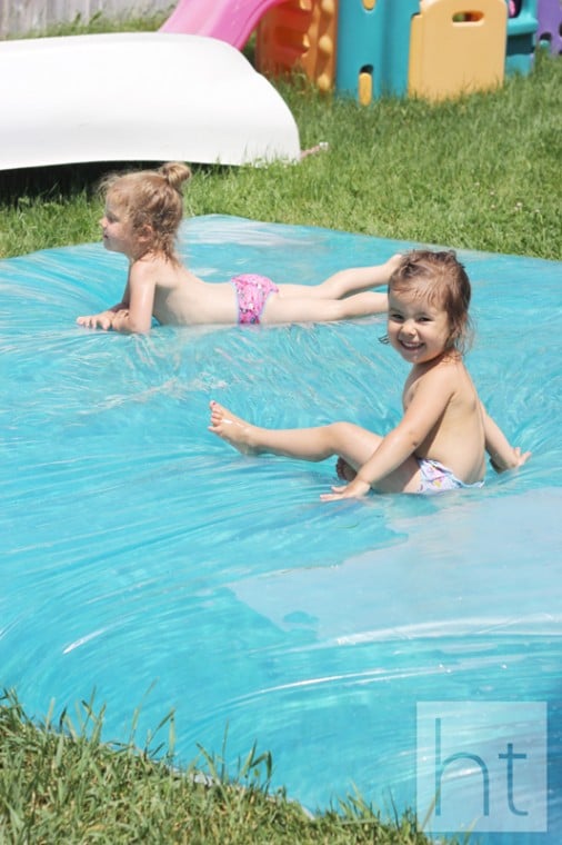 Two kids playing on water blobs.