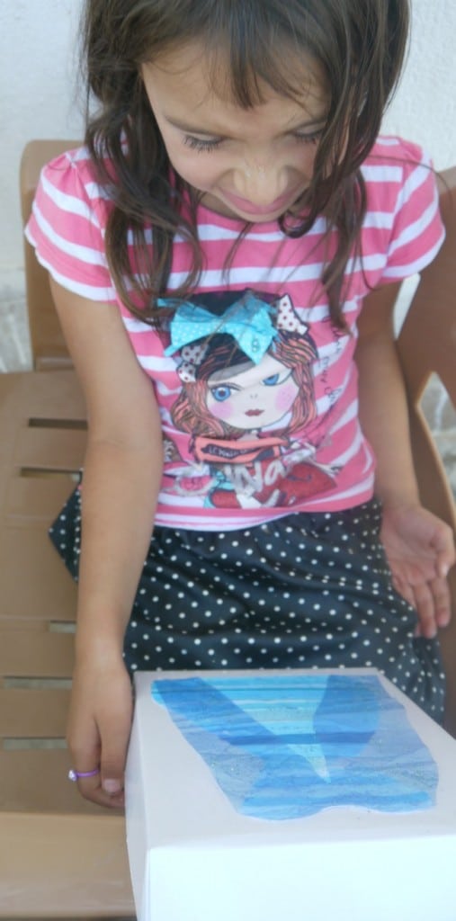 Young girl holding a frozen craft dress package.