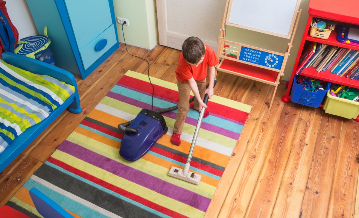 Young boy vacuuming his room.
