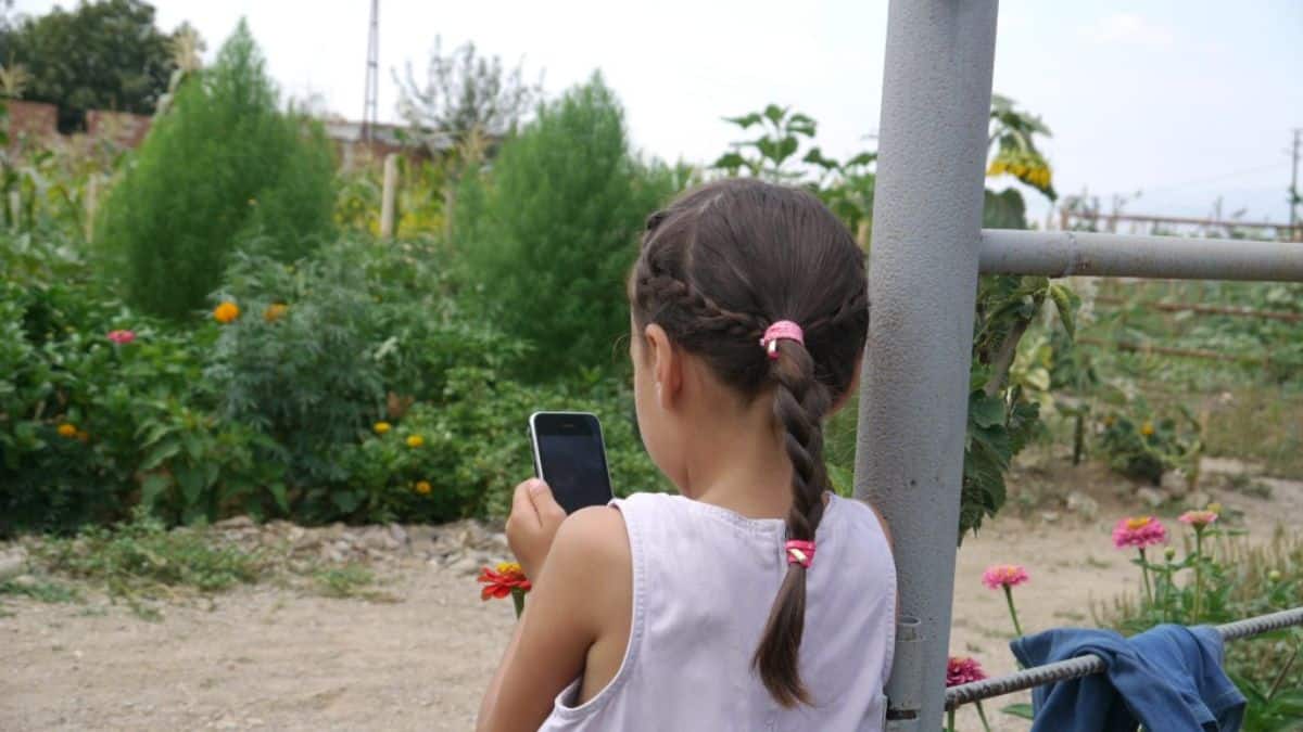 Young girl making an outdoor photo with a smartphone.