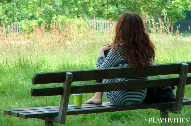 Young girl sitting on a bench alone.