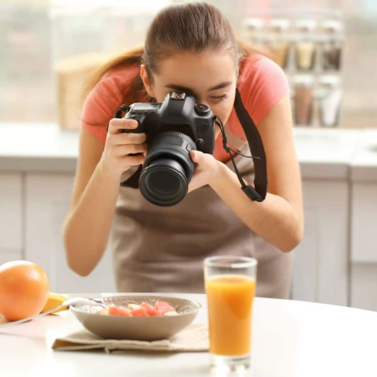 Young woman taking a picture of food on a table.