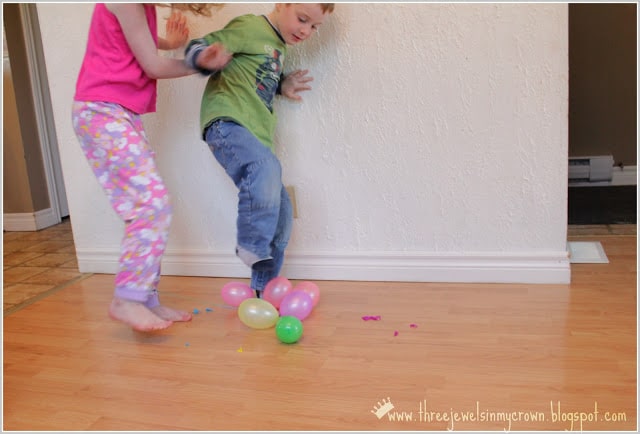 2 kids stepping on balloons.