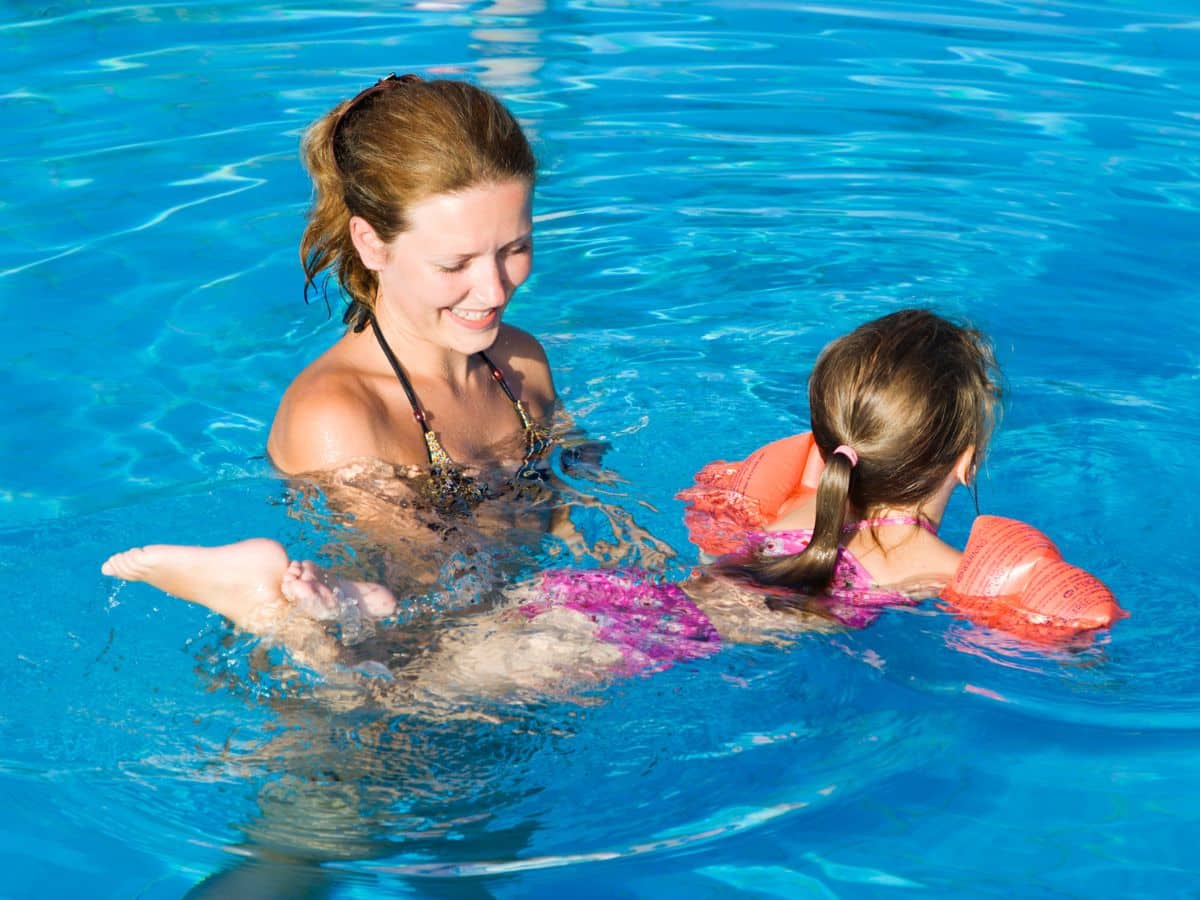 Instructor with kid in a pool.
