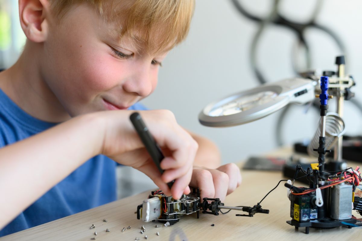 Young boy taking apart electronic device.