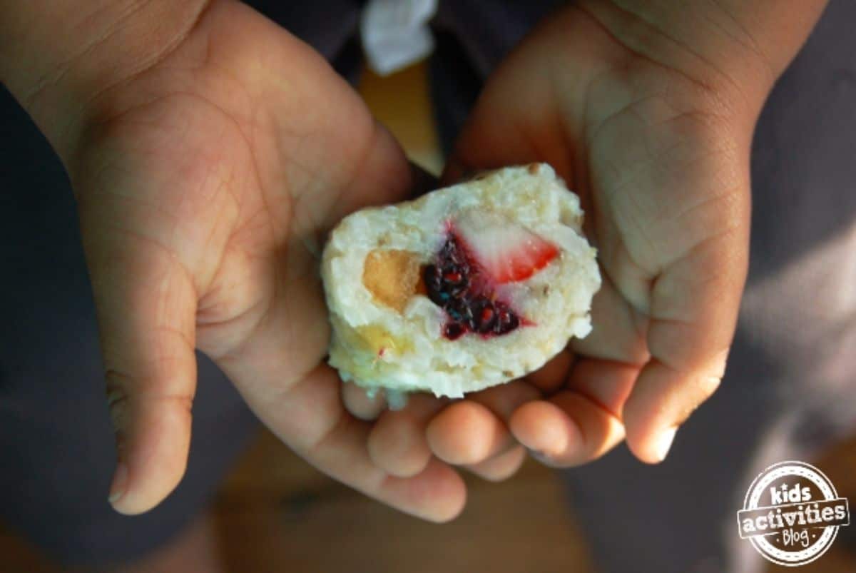 Kid hands holding a frushi snack.