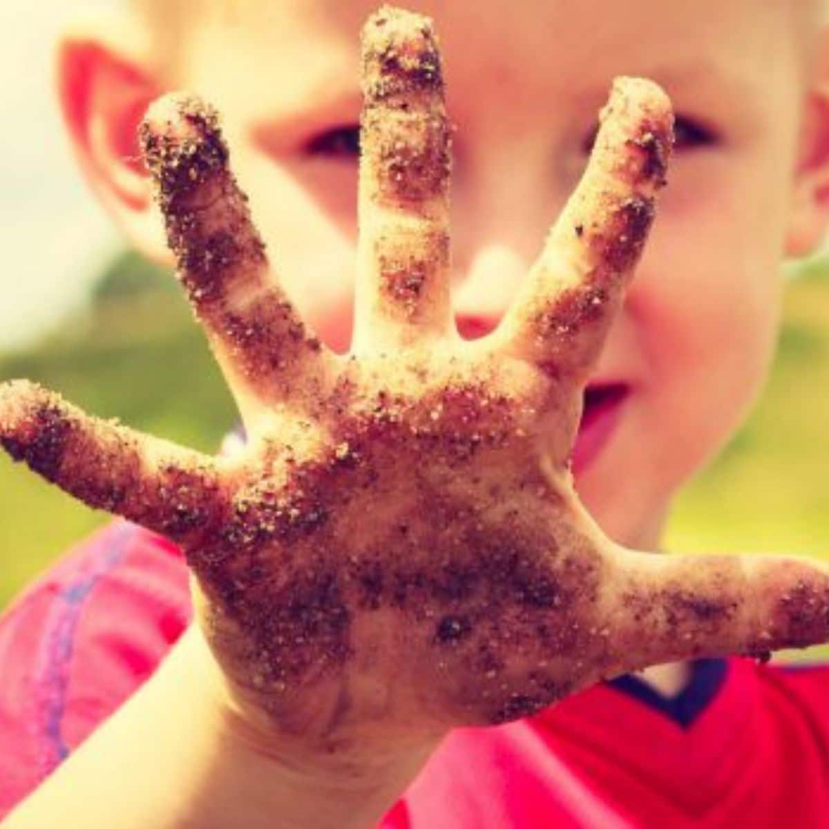 Young boy showing his dirty hand.