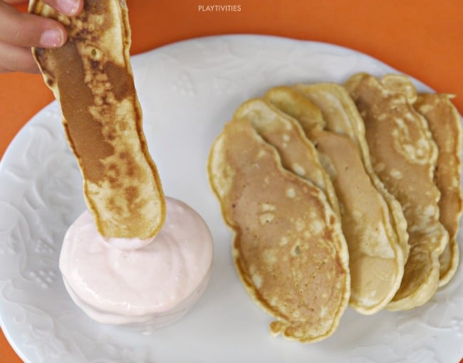 Pancake dippers with yogurt on a plate.
