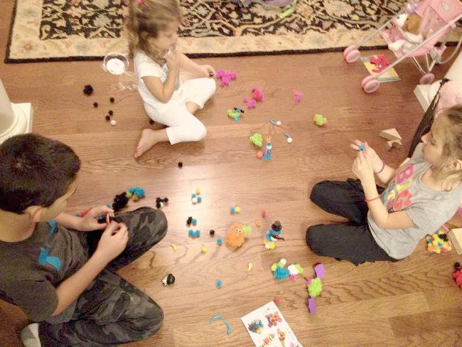 3 kids playing iwth bunchems toys on the floor.