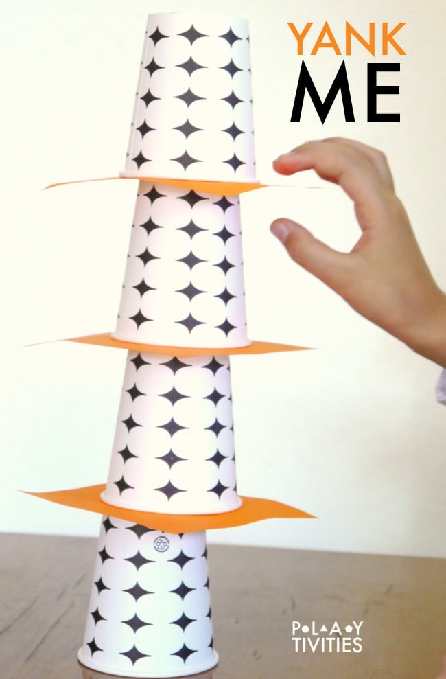 YAnk game poster - pulling out paper sheet between cups.