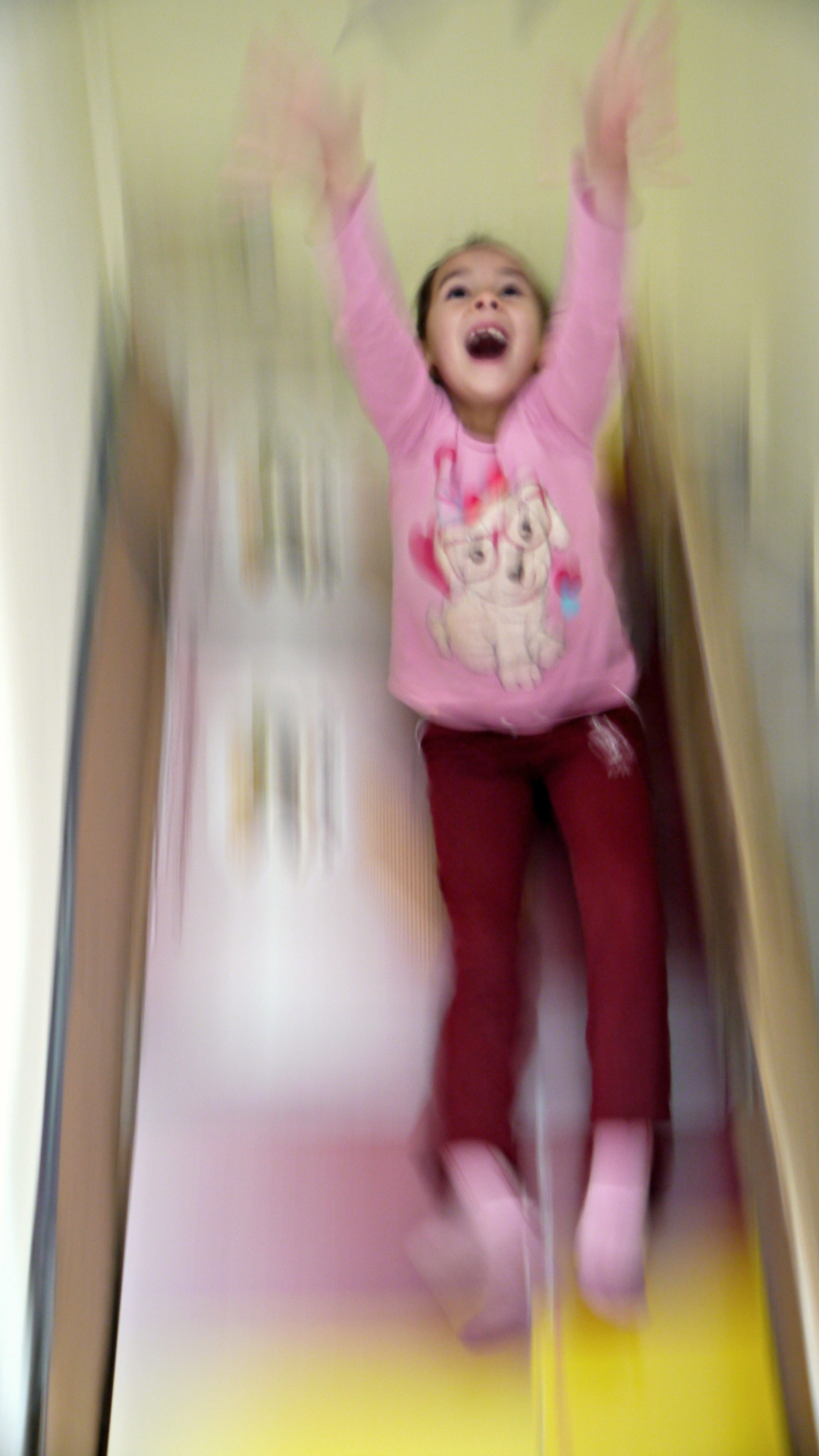 Young girl sliding on a cardboard slide