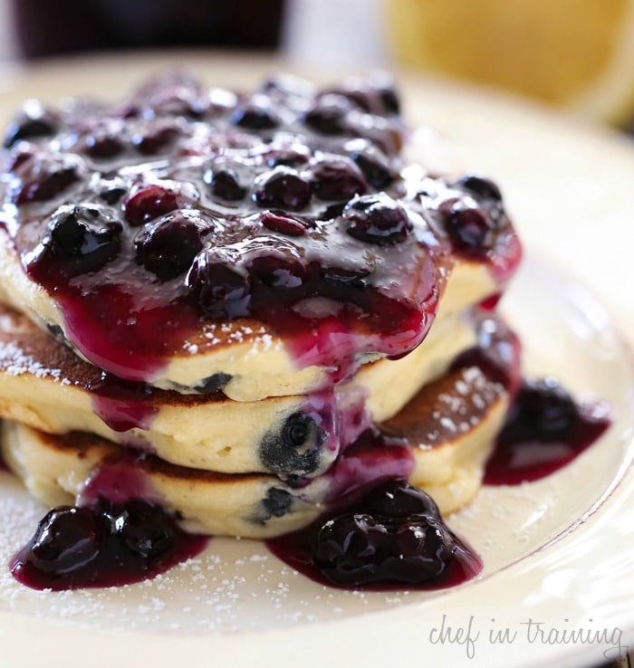 Yummy looking pile of pancakes with blueberry jam on the top.