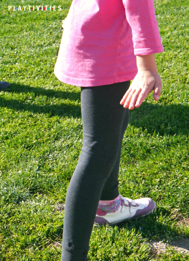 Girl in a pink t-shirt doing funny pose outdoor.