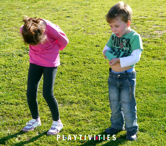 Boy in a green t-shirt and girl in a pink t-shirt playing outside.