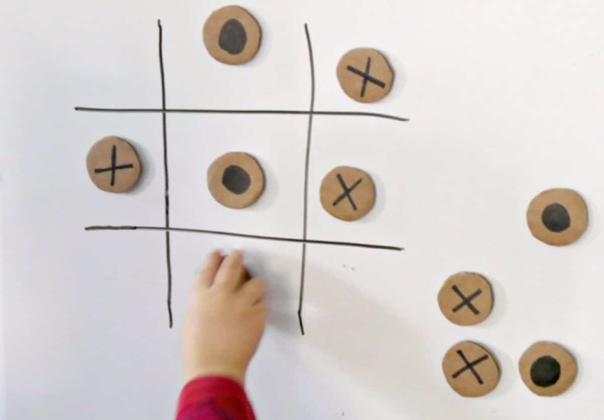 Kid playing with a magnetic tic tac toe.