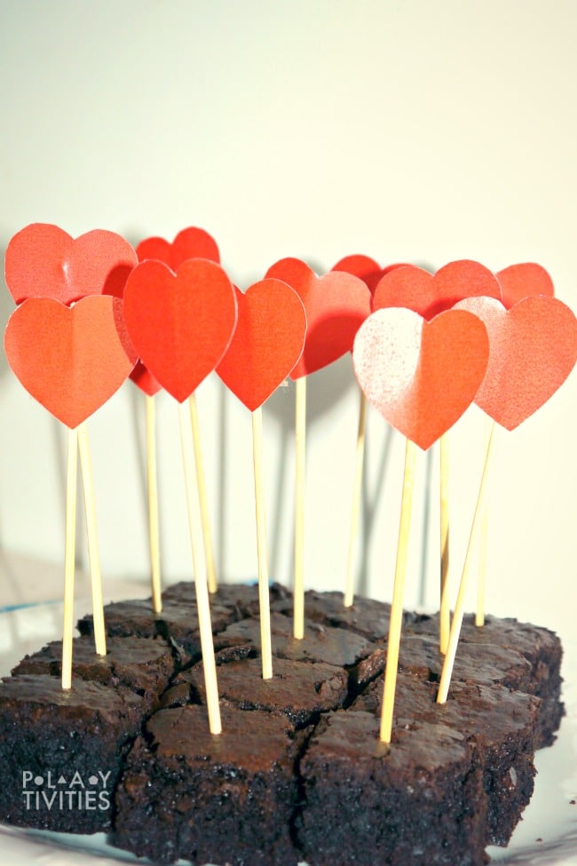 Valentines day brownies with paper hearts on sticks.