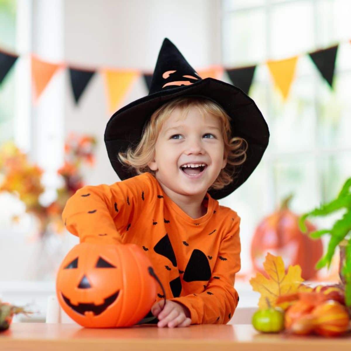 Kid in a halloween costume putting hand in a pumpkin.