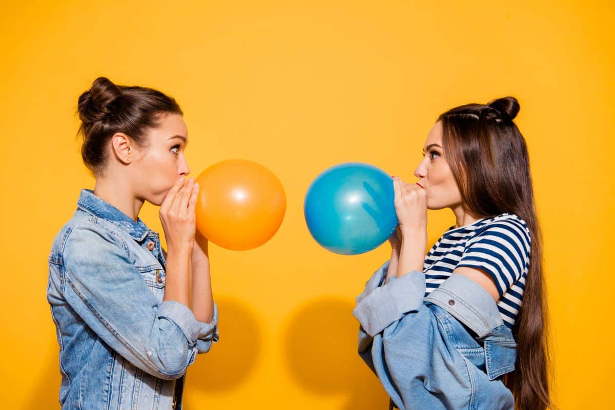 Two girl blowling ballons