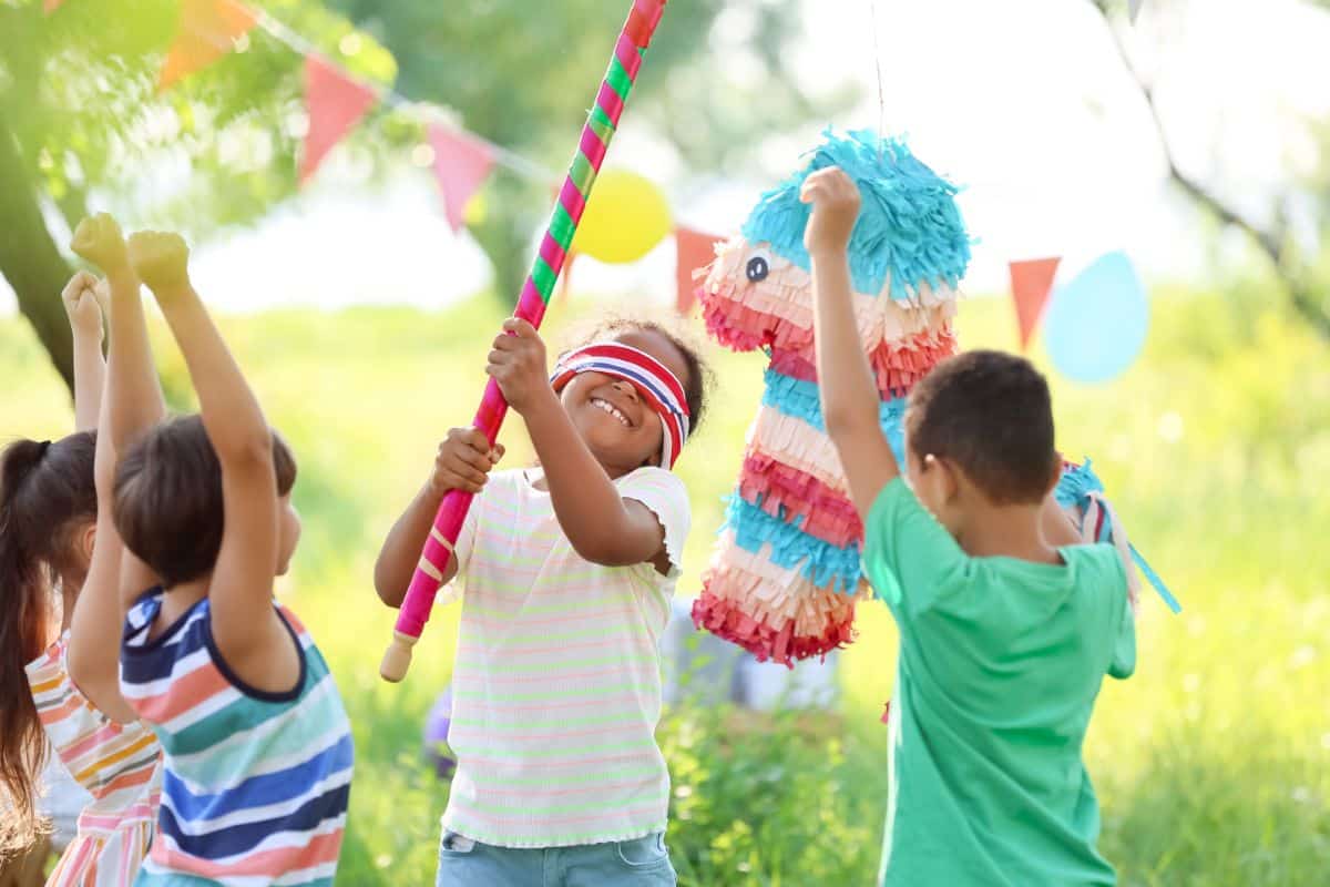 Bunch of childrens playing pinata game.