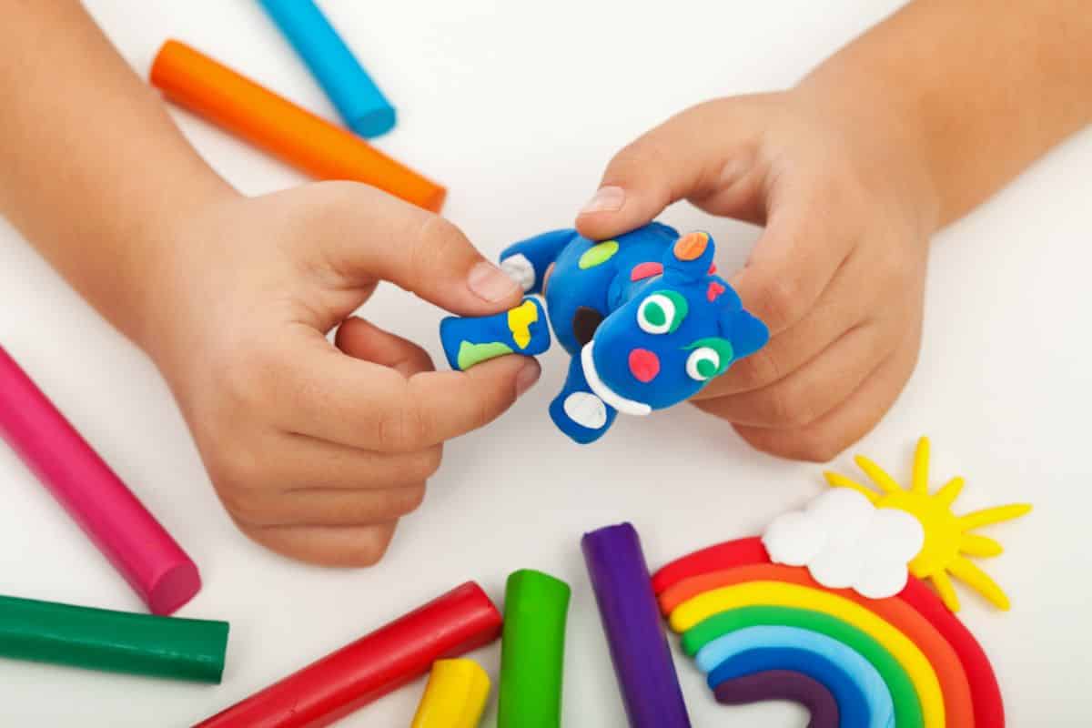 Children playing with a playdough and making a toy.
