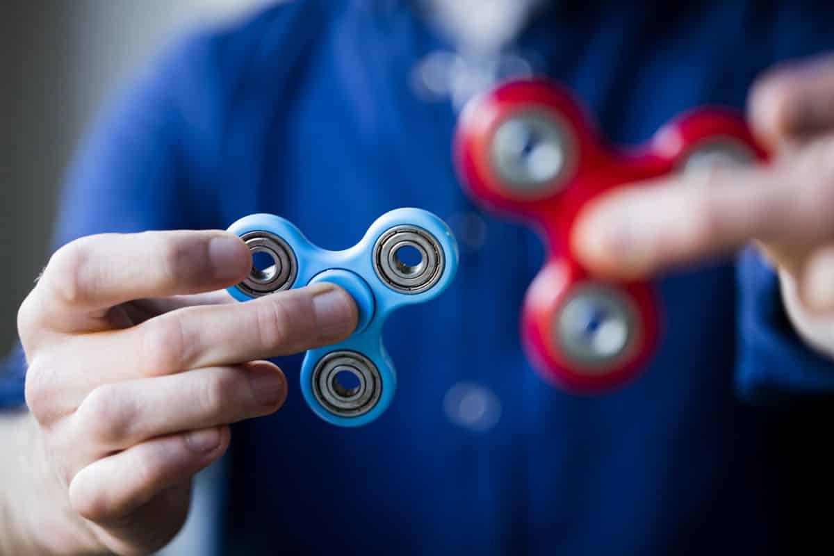Boy hands holding a blue and red fidget spinner.