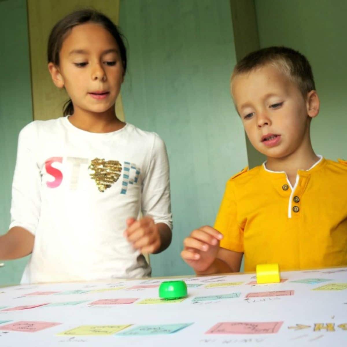 Two young kids playing a board game.