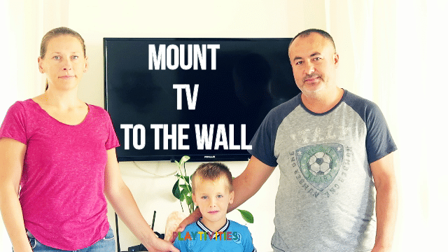 Family standing infron of mounted tv to the wall.