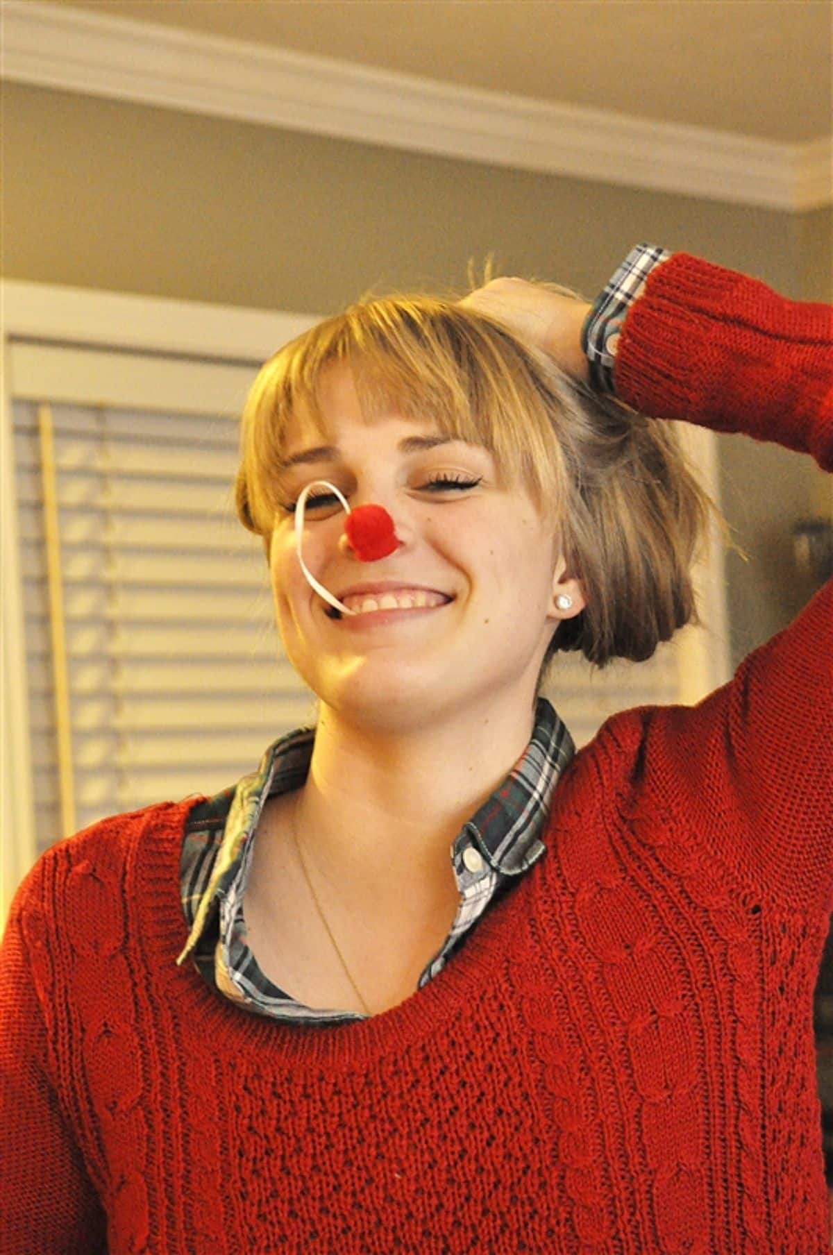 Girl in a red sweater playing a reindeer nose dive game.