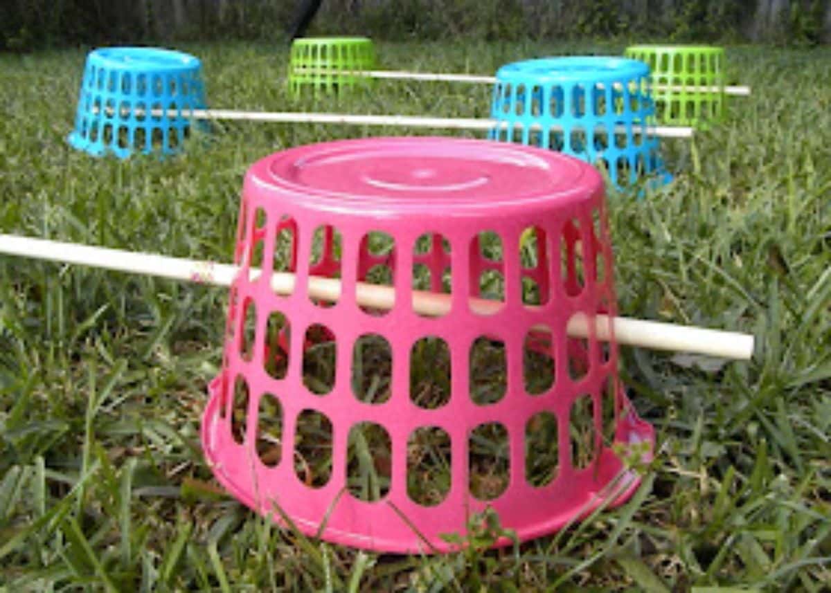 Bunch of colorful plastic baskets with wooden sticks outdoor.