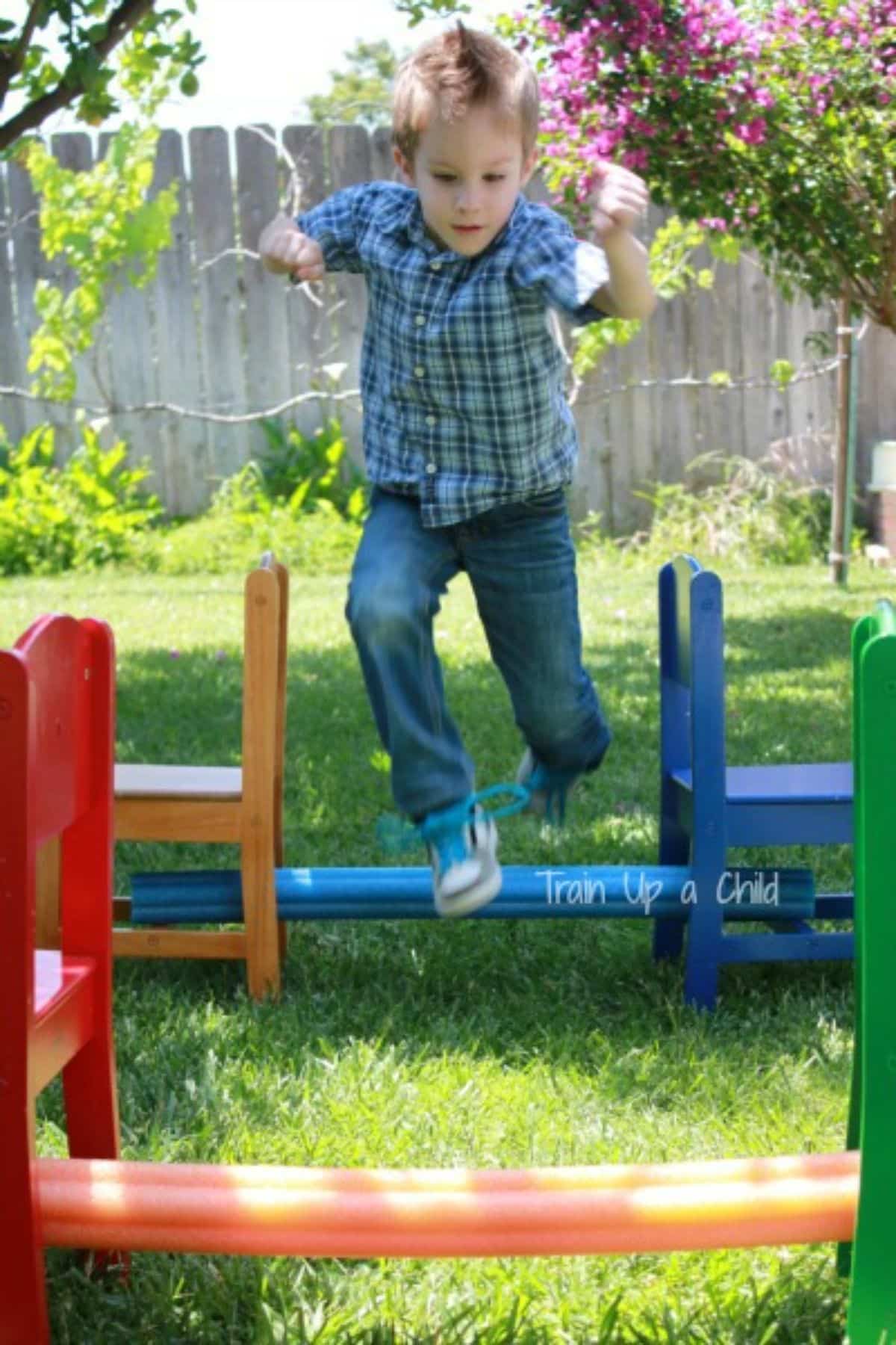 Young boy jumping over obstacles outdoor.
