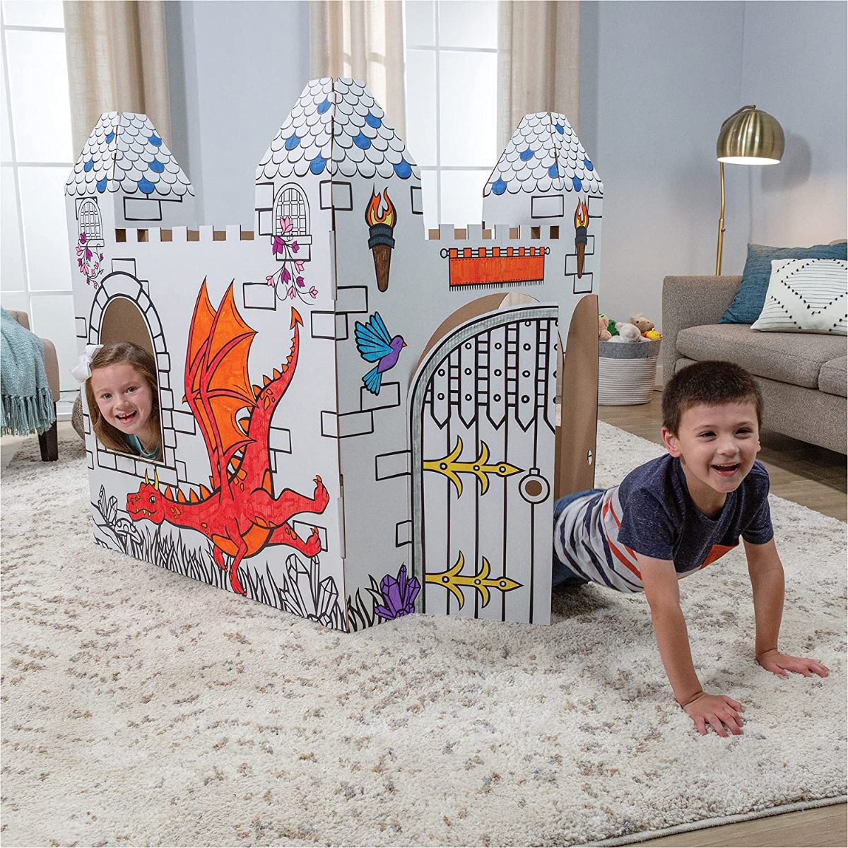 Two kids playing in a cardboard castle.