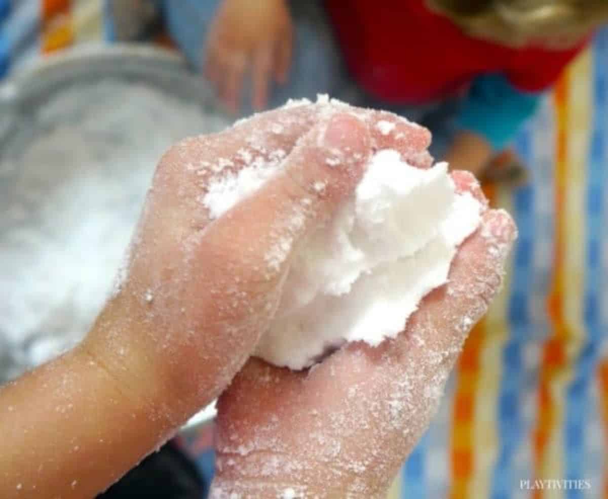 Kid hands holding a fake snow.