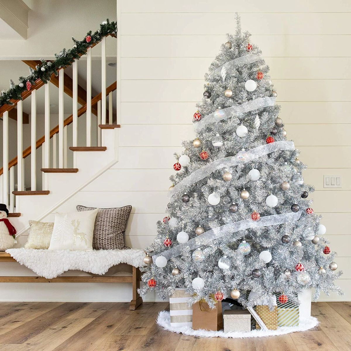 Beautiful christmas tree in a living room with many gifts under.