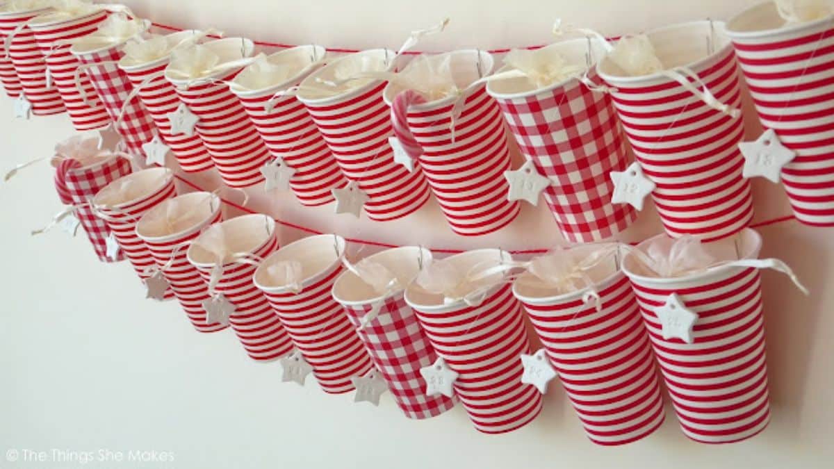 Paper cups hanging on a wall with advent treats