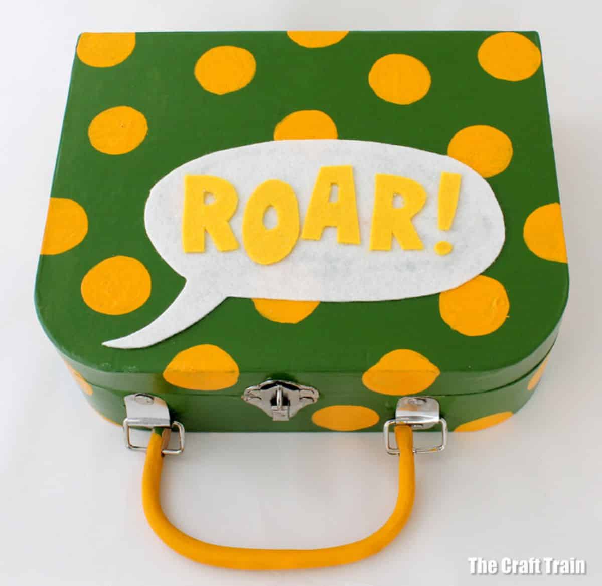 Suprise green-yellow suitcase with sign ROAR!