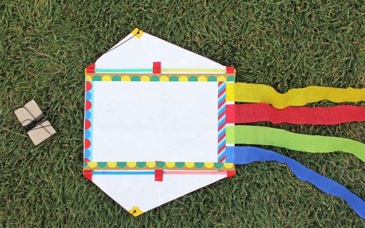 Kite made from recycled mailers on a green grass.