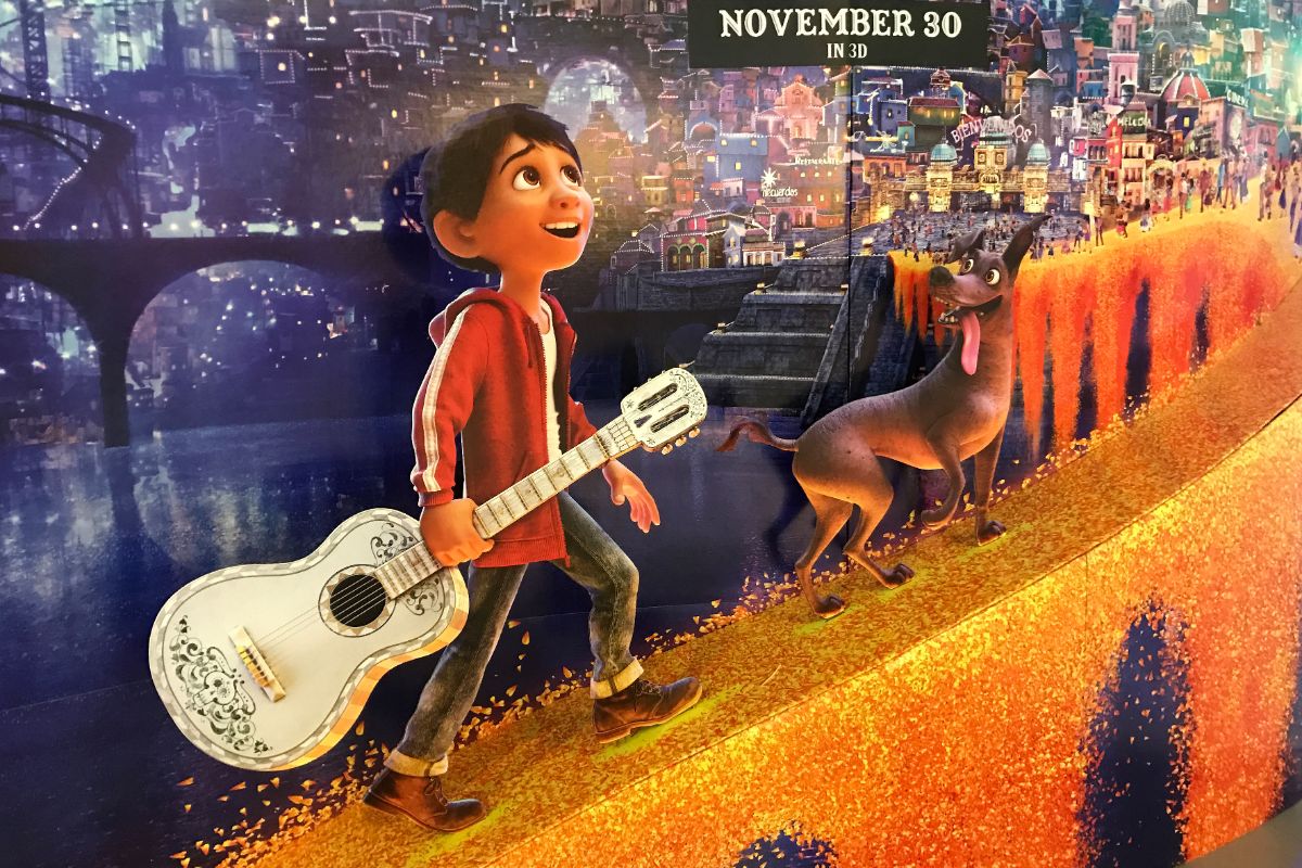 YOung boy holding a guitar next to his dog - Coco Movie concept.