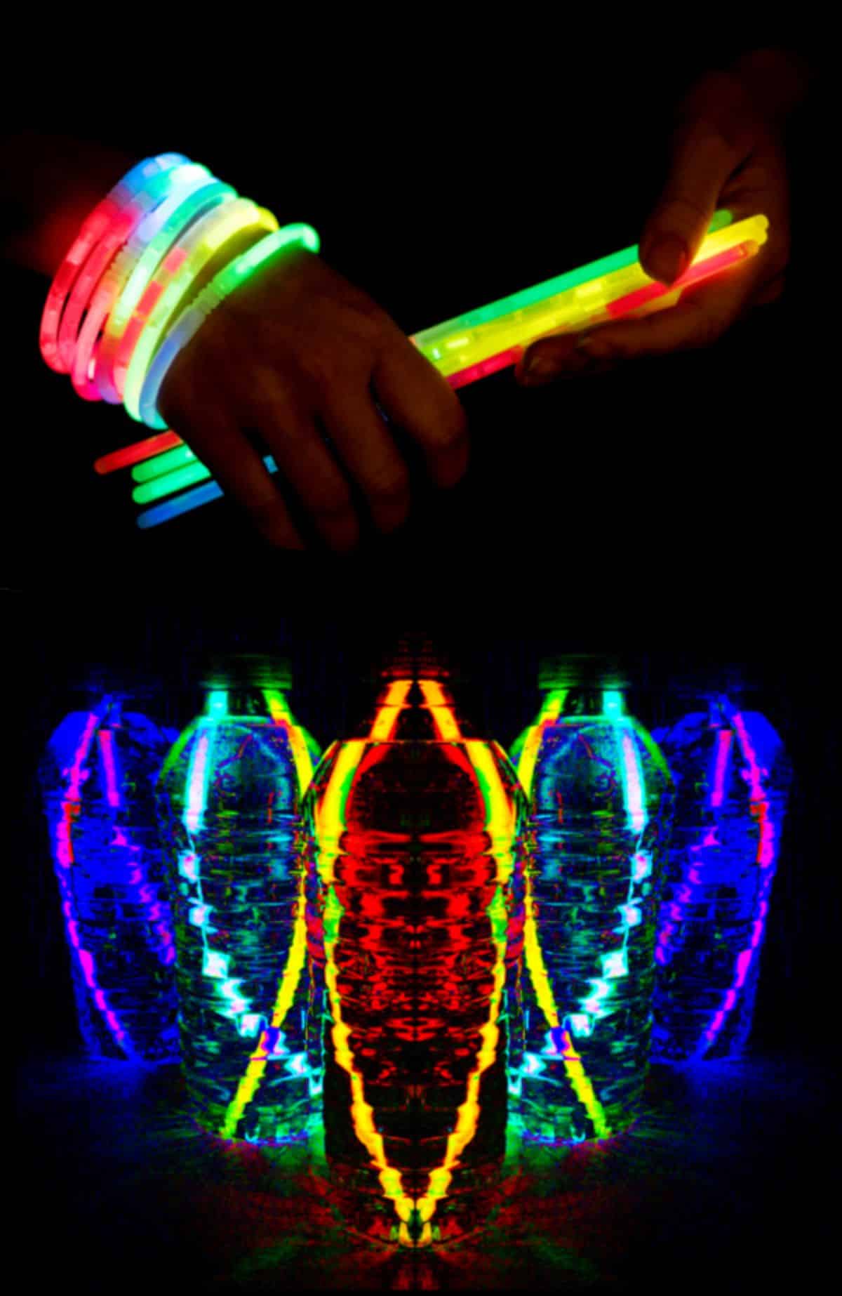 Hands holding and wearing glowing sticks and glowing sticks in bottles glowing in the dark.