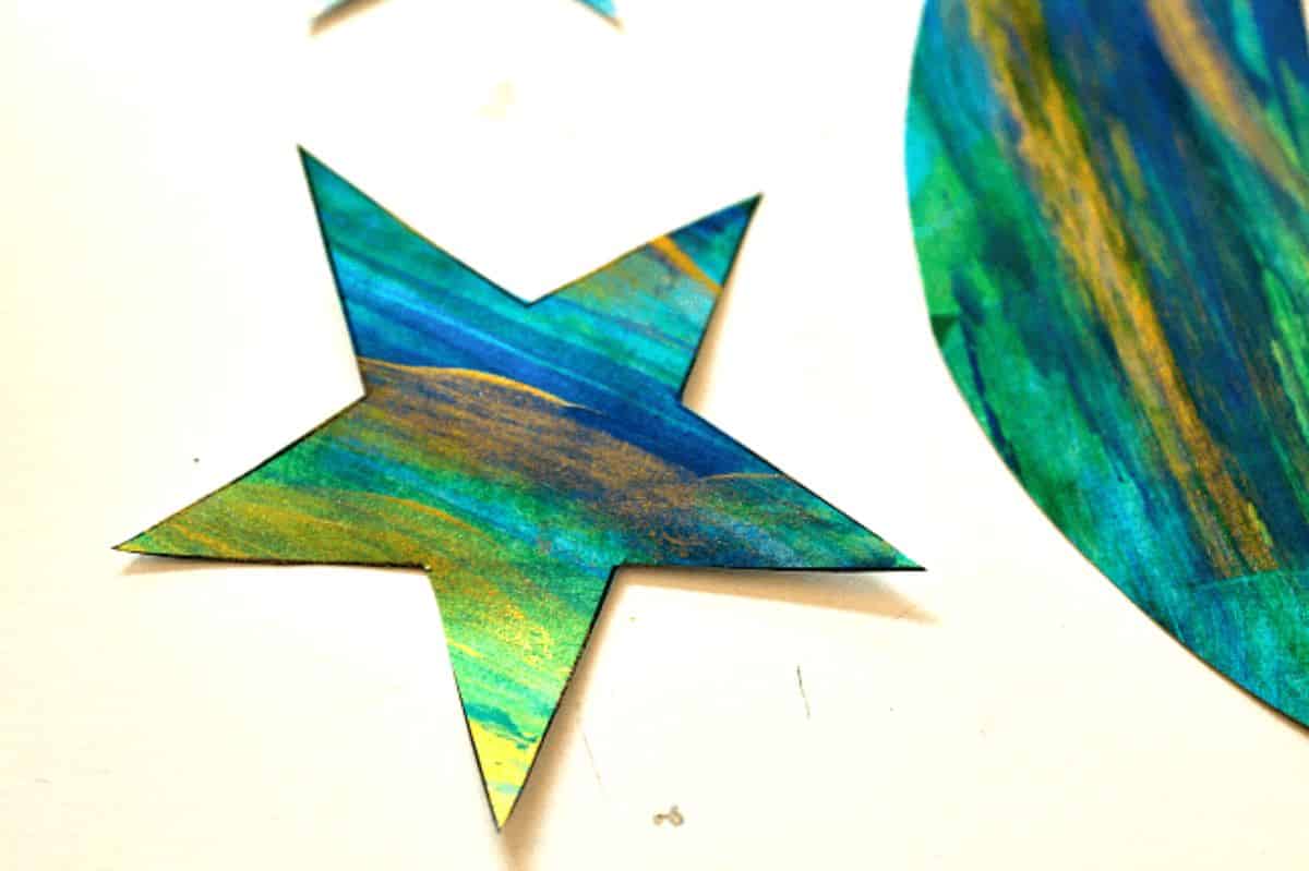 Cardboard painted star as wall hanger on a table.