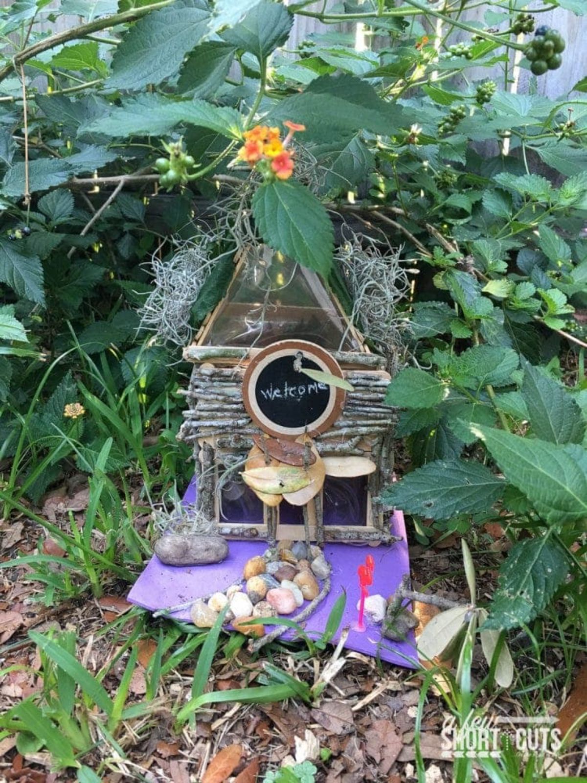 Small fairy house in a garden between plants.