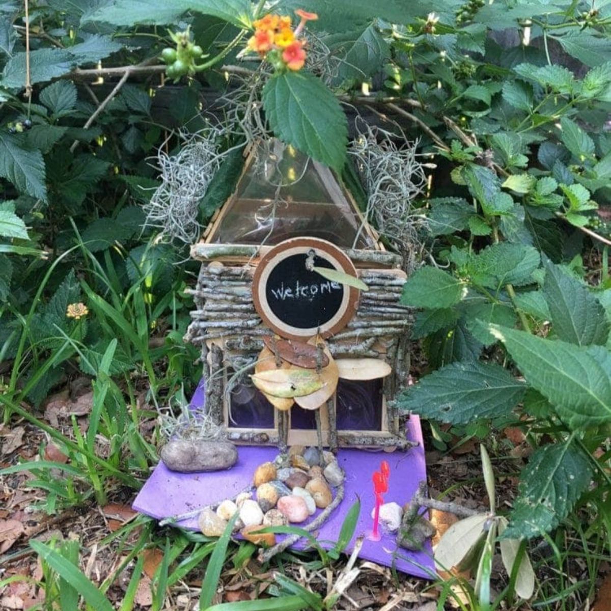 Homemade fairy house in a garden between plants.