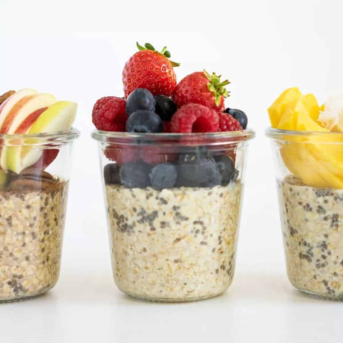 Glass jars full of Overnight Oats with different varieties of fruits.