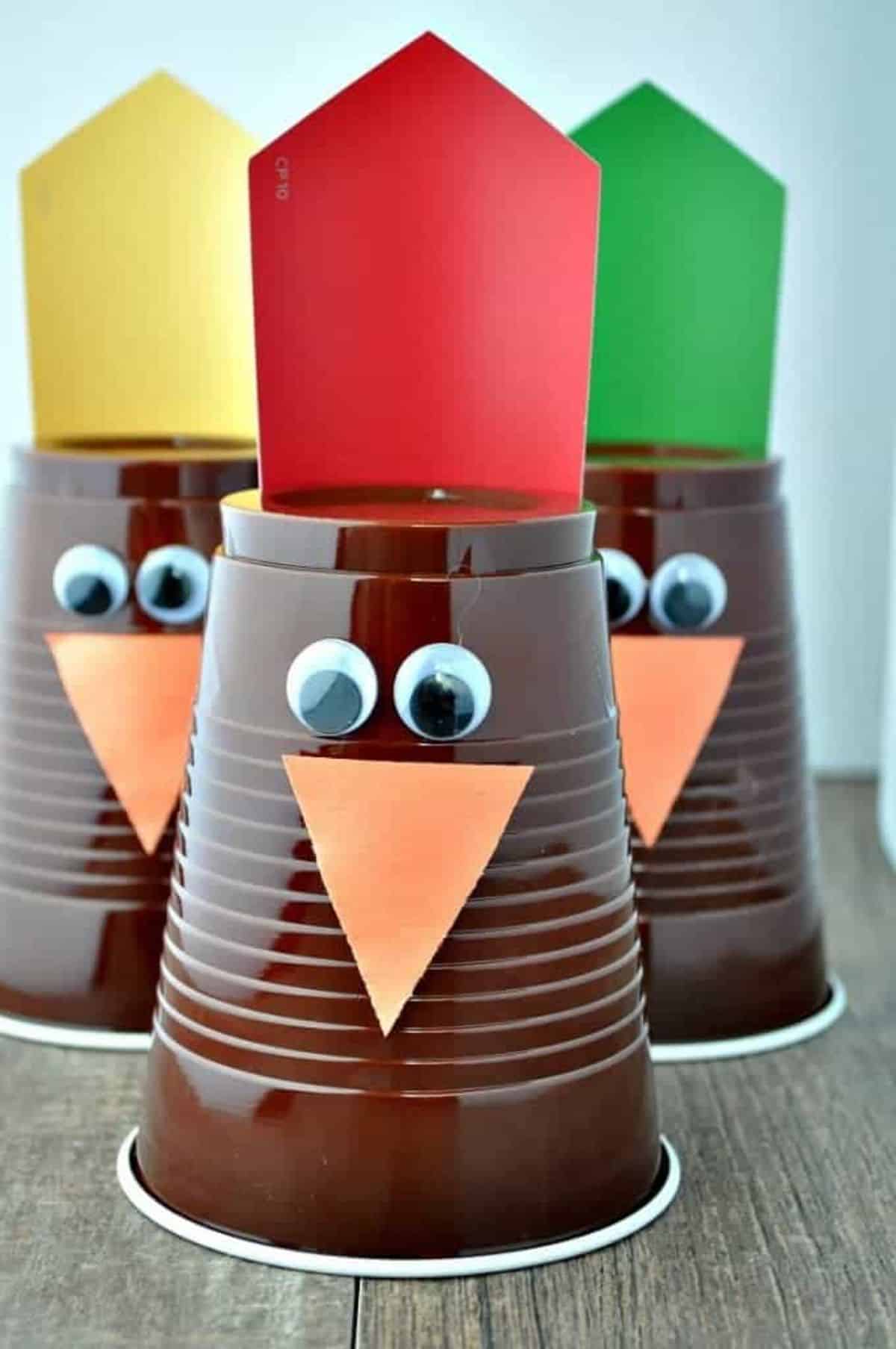 Brown cups decorated as turkeys on the table.