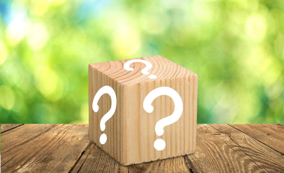 on a table is a wooden block with white question marks on it